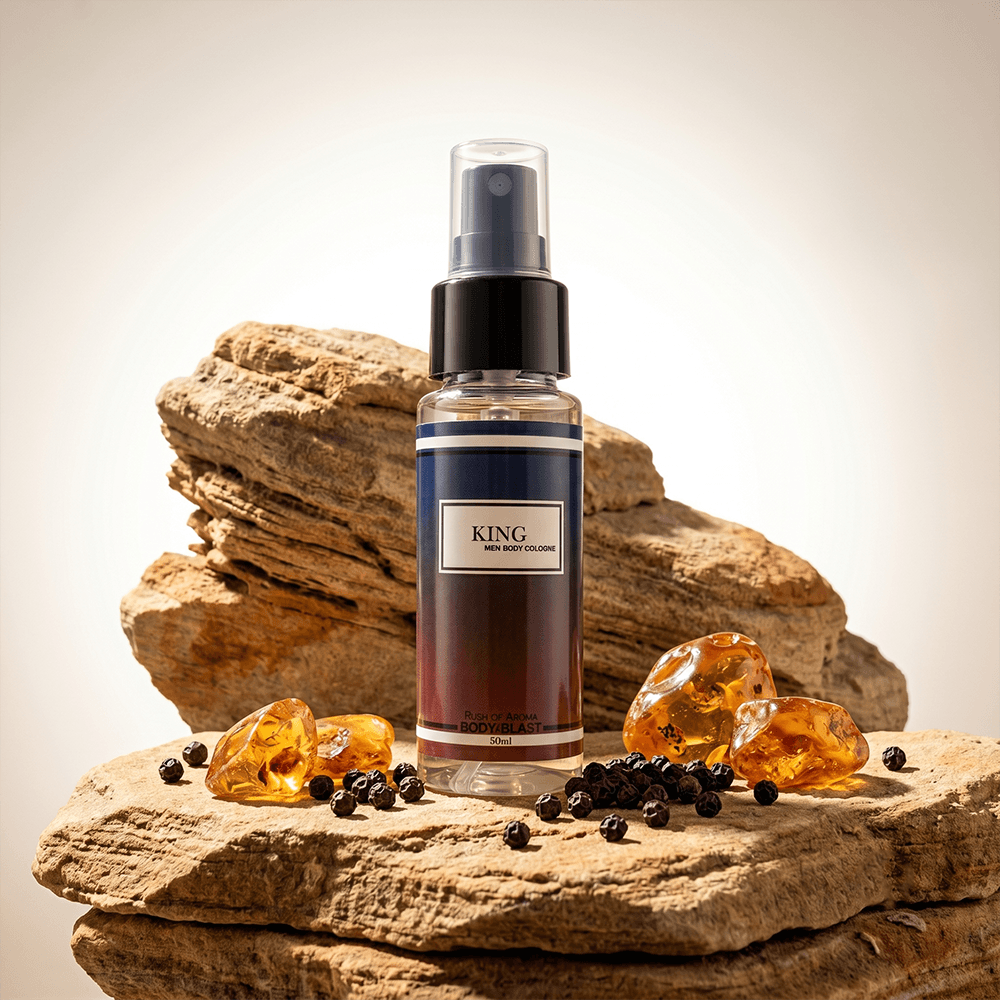 Bottle of 'KING' cologne on a rock with amber stones and black berries