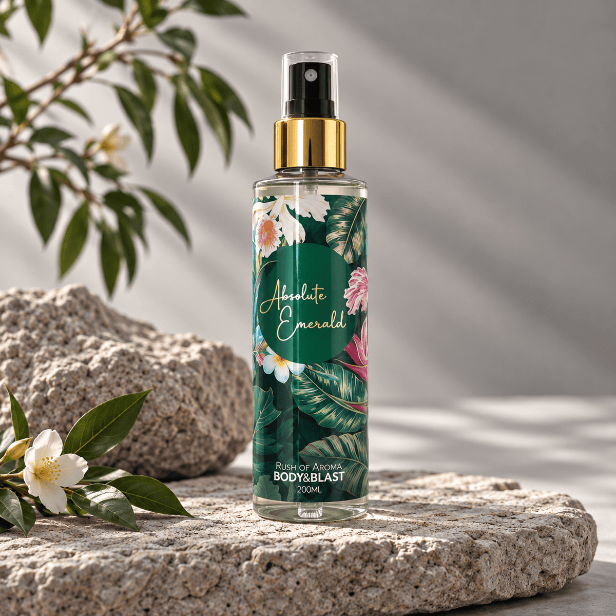 Body spray bottle labeled 'Absolute Emerald' on a natural background with leaves and flowers.